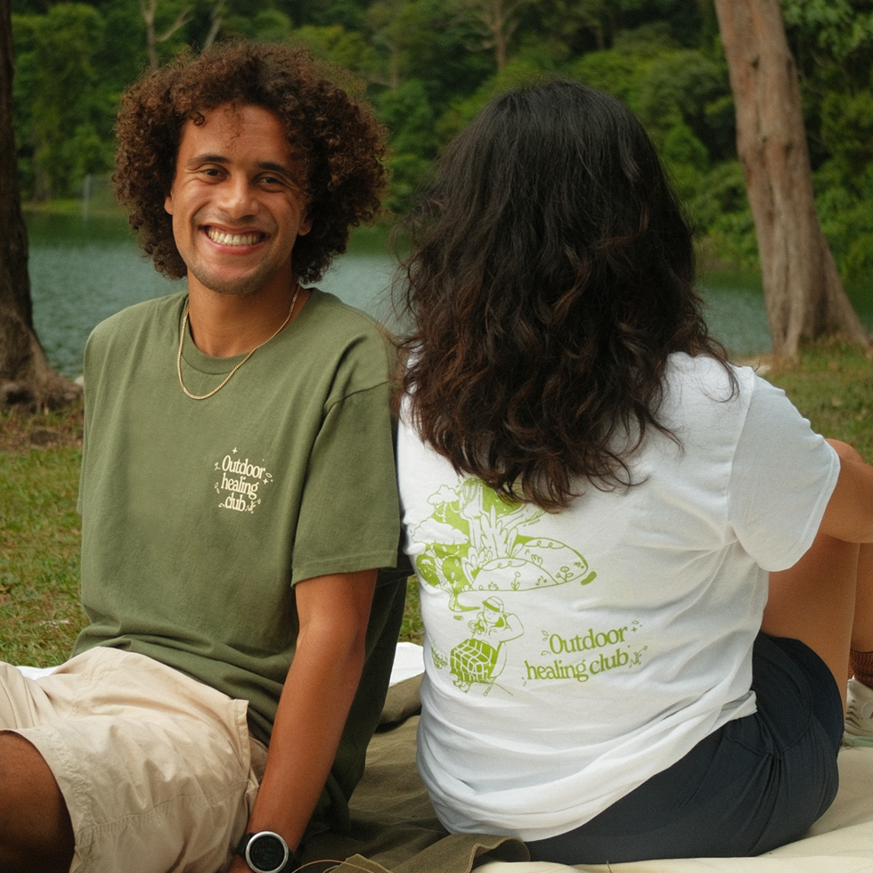 two friends resting at an outdoor picnic in graphic t shirts