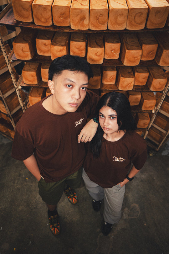 man and woman in a bakery wearing a brown graphic t shirt